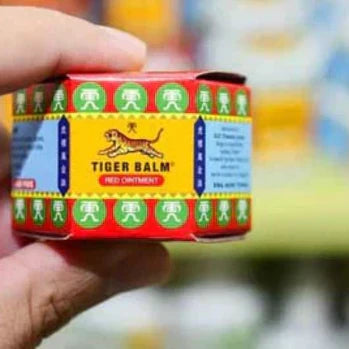 Rotes Tigerbalsam-Gläschen, in einer Hand gehalten.