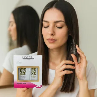 Femme appliquant soin lissant L'Oréal X-Tenso sur cheveux naturels, produit professionnel pour cheveux normaux.