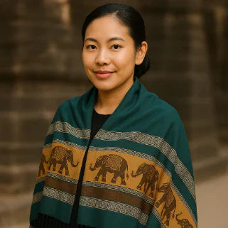 Jeune femme asiatique souriante portant une écharpe pashmina verte et or à motifs d'éléphants.
