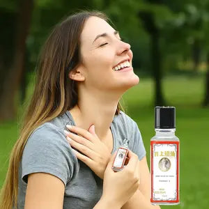 Femme souriante tenant de l'Huile Siang Pure Menthe pour apaiser instantanément les douleurs.