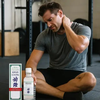 Un homme applique l’huile Kwan Loong sur son cou pour soulager douleur et tension musculaire intense.