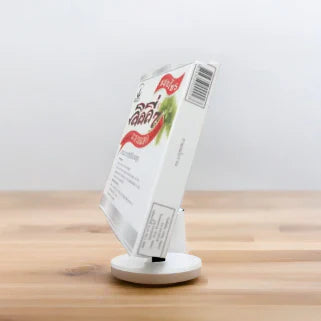 Boîte du produit détox Lilly7, vue de côté, présentée sur un support blanc et une table en bois.