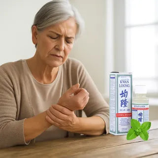 Mujer aplicando aceite Kwan Loong en la muñeca para aliviar dolor en la articulación.