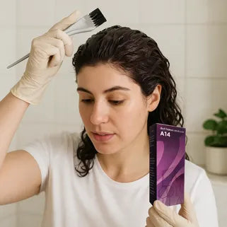 Mujer aplicando un tinte violeta oscuro A14 en cabello grueso en un baño