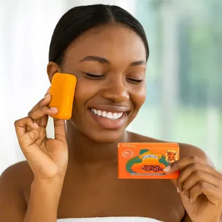 Donna sorridente che applica sapone schiarente alla papaya per uniformare naturalmente l'incarnato.