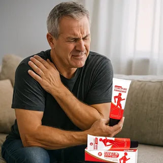 Un homme applique une crème rouge sur son épaule douloureuse, recherchant un soulagement naturel efficace.