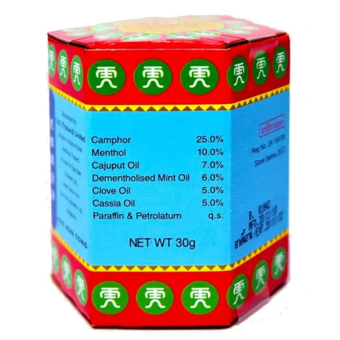 Scatola esagonale di Balsamo di Tigre Rosso con etichetta che elenca gli ingredienti e le loro percentuali. Ingredienti: Canfora, Mentolo, Olio di Cajeput, Olio di Menta Piperita Dementolata, Olio di Chiodi di Garofano, Olio di Cassia, Paraffina e Vaselina. Peso netto: 30 grammi.
