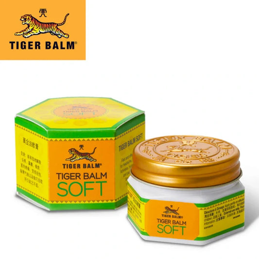 Produit Tiger Balm Soft avec une boîte hexagonale et un petit pot à couvercle doré. Design aux couleurs jaune et verte avec texte en anglais et en chinois indiquant Tiger Balm Soft.