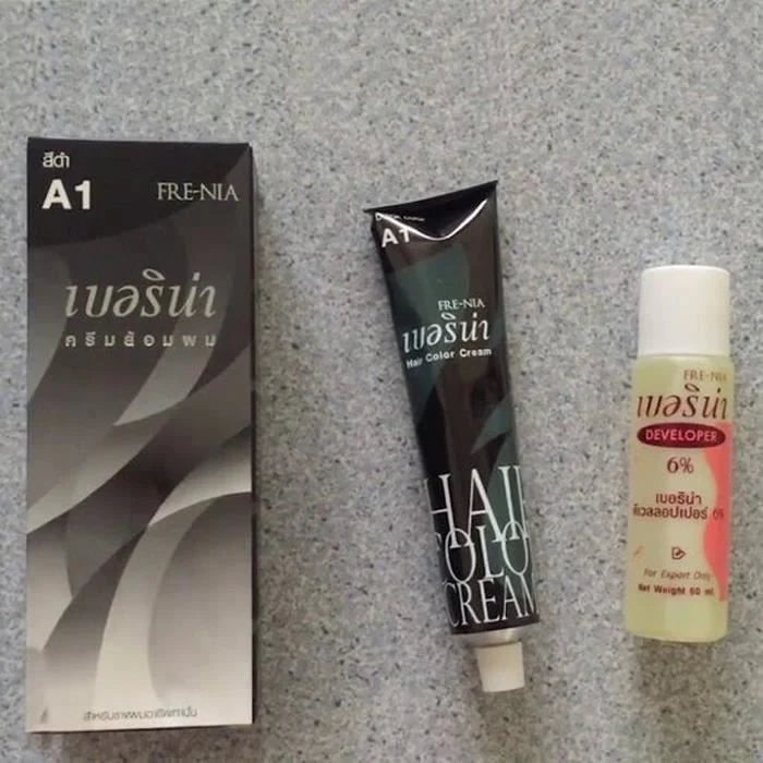 Boîte, tube de crème colorante et développeur 6% FRE-NIA A1 pour cheveux, sur surface grise.