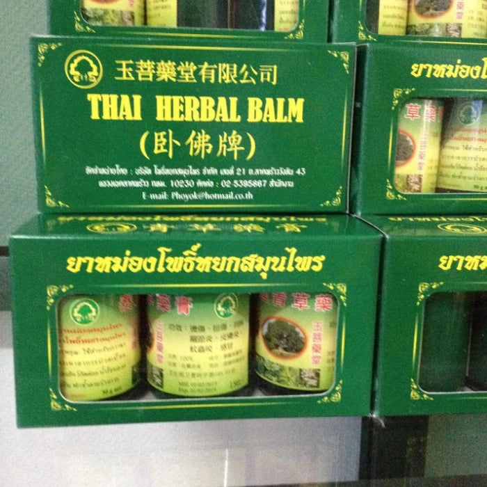 plusieurs boites empilées de 3 Phoyok Baume Vert aux Plantes, une boite a l'inscription : Thai Herbal Balm.
