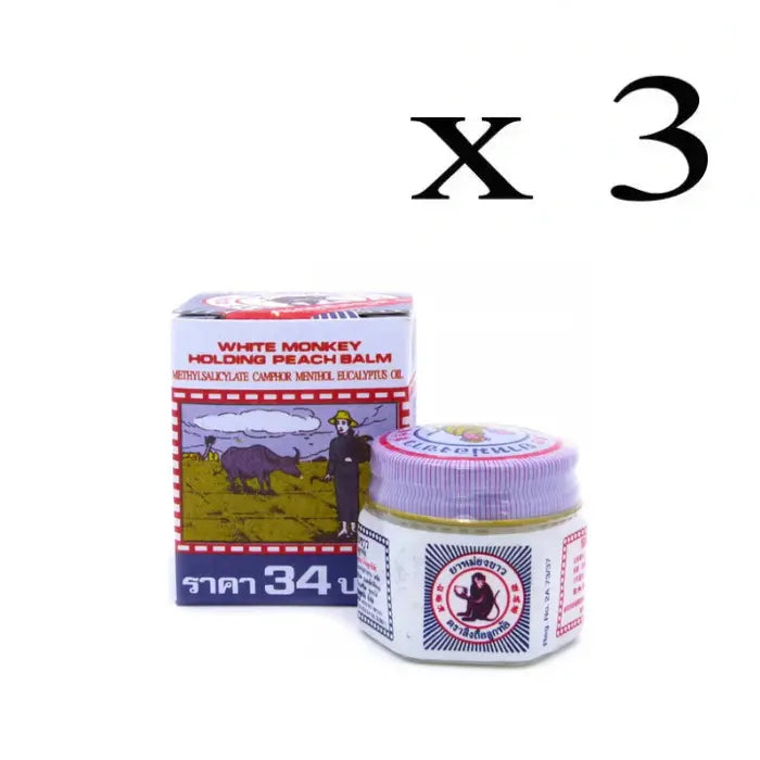 Produit appelé 'White Monkey Holding Peach Balm' avec un pot en verre et son emballage en carton. L'étiquette indique les ingrédients : Methylsalicylate, Camphre, Menthol, Huile d'Eucalyptus. Une illustration sur la boîte montre une personne avec un buffle dans un champ.Lot de 3