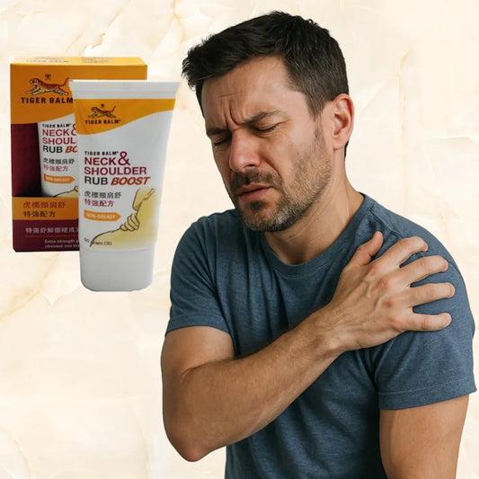Homme aux cheveux bruns, exprimant une douleur à l'épaule, avec une crème Tiger Balm Neck & Shoulder Rub Boost.