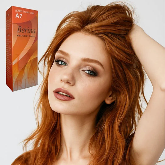 Jeune femme rousse aux yeux bleus, une main dans les cheveux, posant à côté d'une boîte de teinture capillaire Berina A7 couleur marron doré.