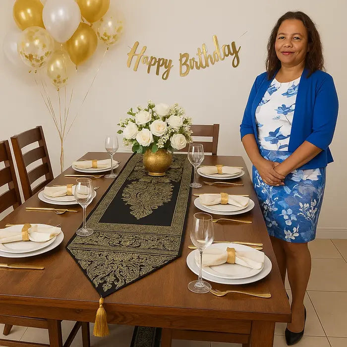 Une femme en robe bleue et blanche se tient près d'une table élégamment décorée pour un anniversaire.