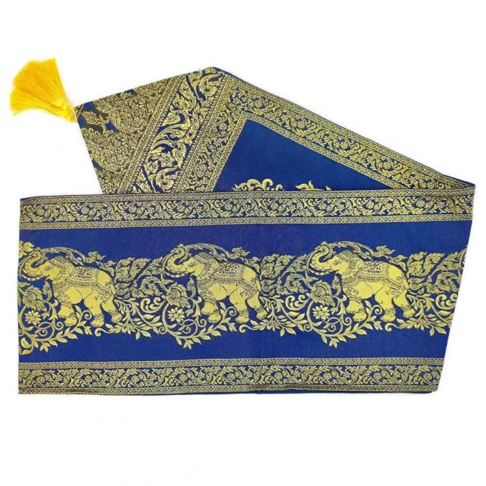 Blått thailändskt tyg dekorerat med gyllene blom- och elefantmotiv, med gula fransar. Raffinerad traditionell dekoration