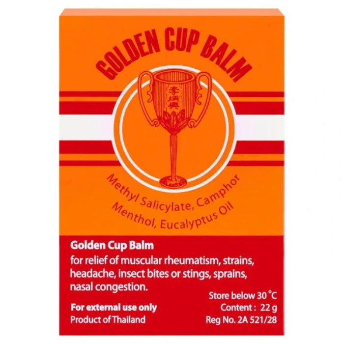 Tubes de baume Golden Cup et son emballage, principalement orange avec des accents rouges et blancs. Texte en anglais et en thaï, indiquant les ingrédients et les utilisations du produit.