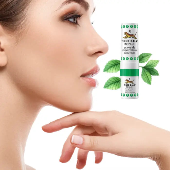 Лицо женщины в профиль и карманный ингалятор Tiger Balm перед ее лицом.