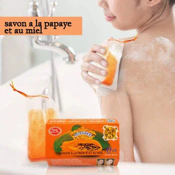 Femme utilisant un sac exfoliant orange sous la douche. Emballage du produit visible