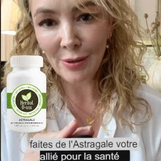 Une femme souriante présente un complément Herbal D-Lux avec Astragale, promouvant ses bienfaits pour la santé.