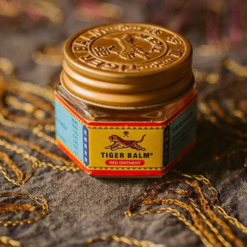 Pot de baume du tigre sur tissu doré, remède traditionnel asiatique