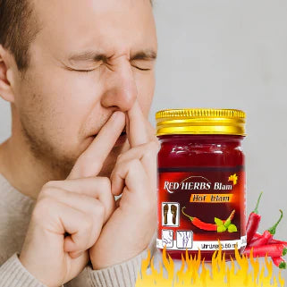 Un homme souffre en touchant son nez après application de baume rouge thaïlandais très puissant.