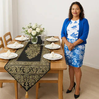 Une femme debout près d'une table élégamment dressée avec des assiettes et des fleurs.