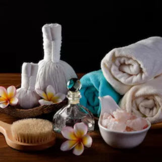 ensemble d'accessoires pour un soin de spa, incluant des serviettes, des brosses, des flacons et des compresses d'herbes