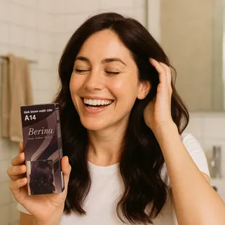 Donna sorridente con capelli tinti che tiene una scatola di tintura per capelli Berina A14.