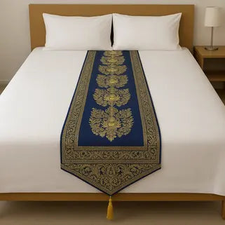 Dessus de lit bleu orné de motifs dorés sur un lit blanc