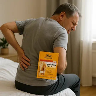 Homme souffrant du dos appliquant un patch antidouleur Baume du Tigre dans sa chambre. 