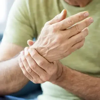 Personne se massant le poignet pour soulager une douleur articulaire