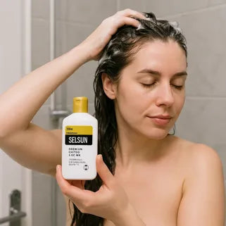  Mujer aplicando champú Selsun para tratar la dermatitis seborreica en la ducha.