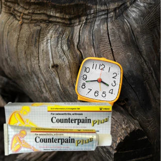 Une horloge analogique posée sur des boîtes de médicaments contre la douleur.