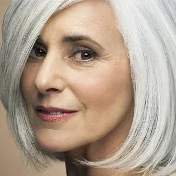 Femme élégante aux cheveux gris argentés sourit avec confiance