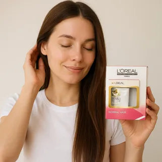 Donna sorridente che tiene in mano un prodotto L'Oréal Pro X-Tenso per capelli lisci e setosi.