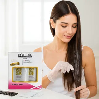 Femme applique soin lissant L'Oréal X-Tenso sur cheveux normaux avec gants, boîte visible devant.