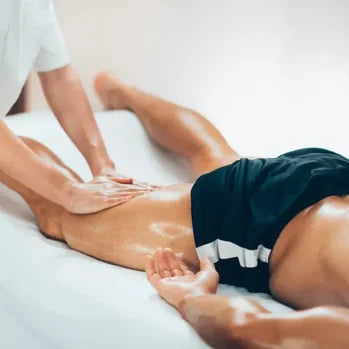 Massage des jambes d'un client allongé sur une table de massage