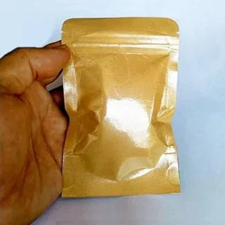   Petit sachet en papier kraft avec fermeture zip, tenu par une main contre fond blanc.