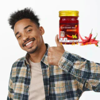 Un uomo sorridente tiene un barattolo di peperoncino rosso con peperoncini freschi accanto.