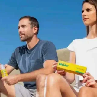 Un couple sur la plage, tenant des produits namman muay, symbolisant le bien-être et la relaxation articulaire .