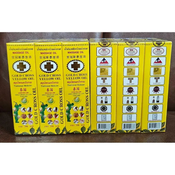 Image montrant six boîtes jaunes de Gold Cross Yellow Oil, un remède traditionnel thaïlandais utilisé pour soulager douleurs musculaires, tensions et piqûres d’insectes. Le packaging jaune vif comporte une croix noire, des illustrations d’usage et plusieurs logos de certification thaïlandais.