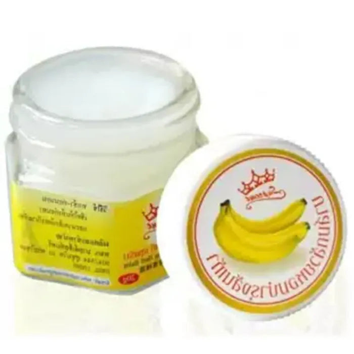 Petit pot de baume hydratant Supreme à base de banane, présenté ouvert avec une texture crémeuse visible. Le couvercle décoré de bananes est posé à côté. L’image met en avant un soin nourrissant destiné à adoucir et réparer la peau sèche des talons.