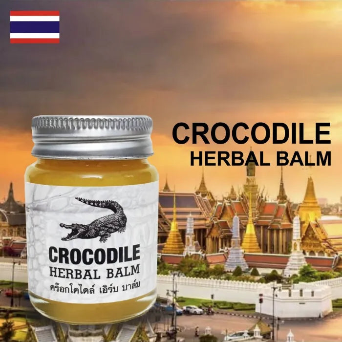 Pot de Crocodile Herbal Balm devant un décor thaïlandais au coucher du soleil. Baume traditionnel utilisé pour apaiser irritations, petites blessures et inconforts cutanés. Packaging avec crocodile, évoquant un soin puissant et protecteur d’origine thaïlandaise.