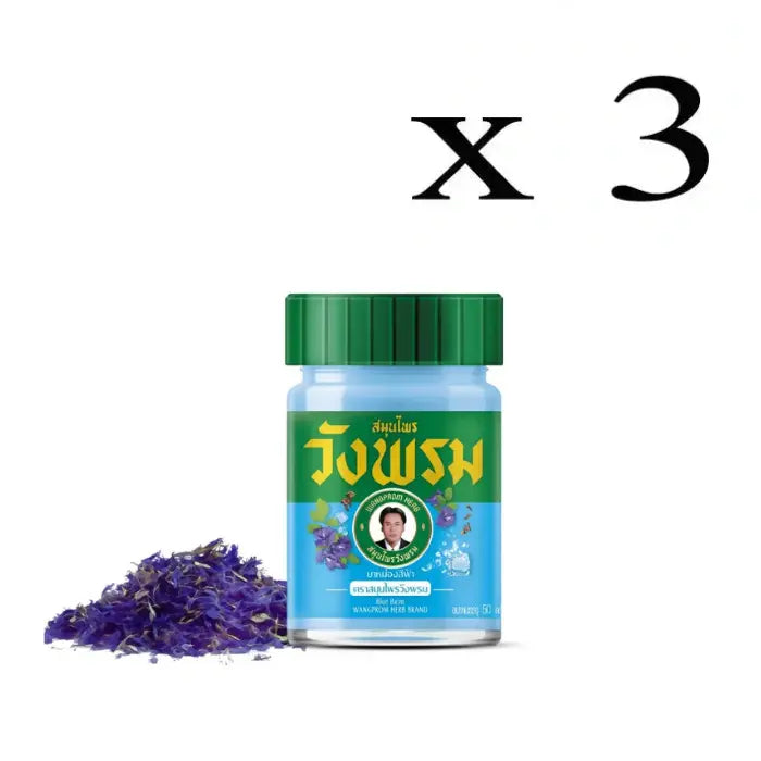 3 Flacons de Baume Wang Prom bleu, avec des fleurs séchées de pois bleu dispersées à côté, mettant en avant le produit et son ingrédient principal.