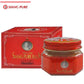 Produit Baume Jaune Siang Pure, avec un pot en verre à couvercle rouge et une boîte rouge assortie. Étiquette avec portrait en noir et blanc et texte YELLOW SIANG PURE BALM.
