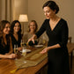 Une femme verse du champagne à des invitées souriantes autour d'une table élégamment décorée.
