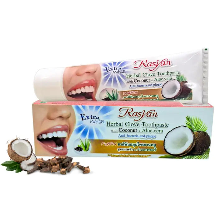 Image d’un dentifrice Rasyan Extra White Herbal Clove Toothpaste, présenté dans une boîte illustrant un sourire aux dents blanches, une noix de coco ouverte et des feuilles d’aloe vera. Le packaging met en avant une formule aux herbes, clou de girofle, coco et aloe vera, anti‑bactérienne et anti‑plaque