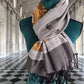 Élégant foulard cachemire et soie gris et doré exposé sur mannequin, dans un palais classique raffiné.