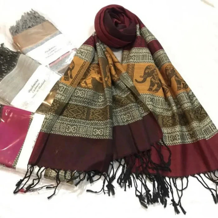 2 Foulard Pashmina posées au sol avec 3 pashminas en second plan dans leur emballage