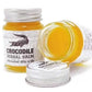 Deux pots de Crocodile Herbal Balm, dont un ouvert révélant un baume jaune. Baume traditionnel utilisé pour apaiser irritations, douleurs légères et inconforts cutanés. Packaging avec crocodile, évoquant un soin puissant et protecteur.